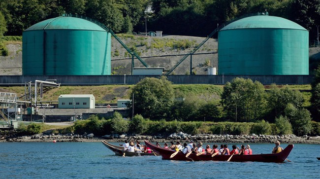 First Nations canoes paddle on the waters of Burrard Inlet to the Kinder Morgan Burnaby Terminal of the Trans Mountain pipeline, in North Vancouver, B.C., on September 1, 2012. THE CANADIAN PRESS/Darryl Dyck.