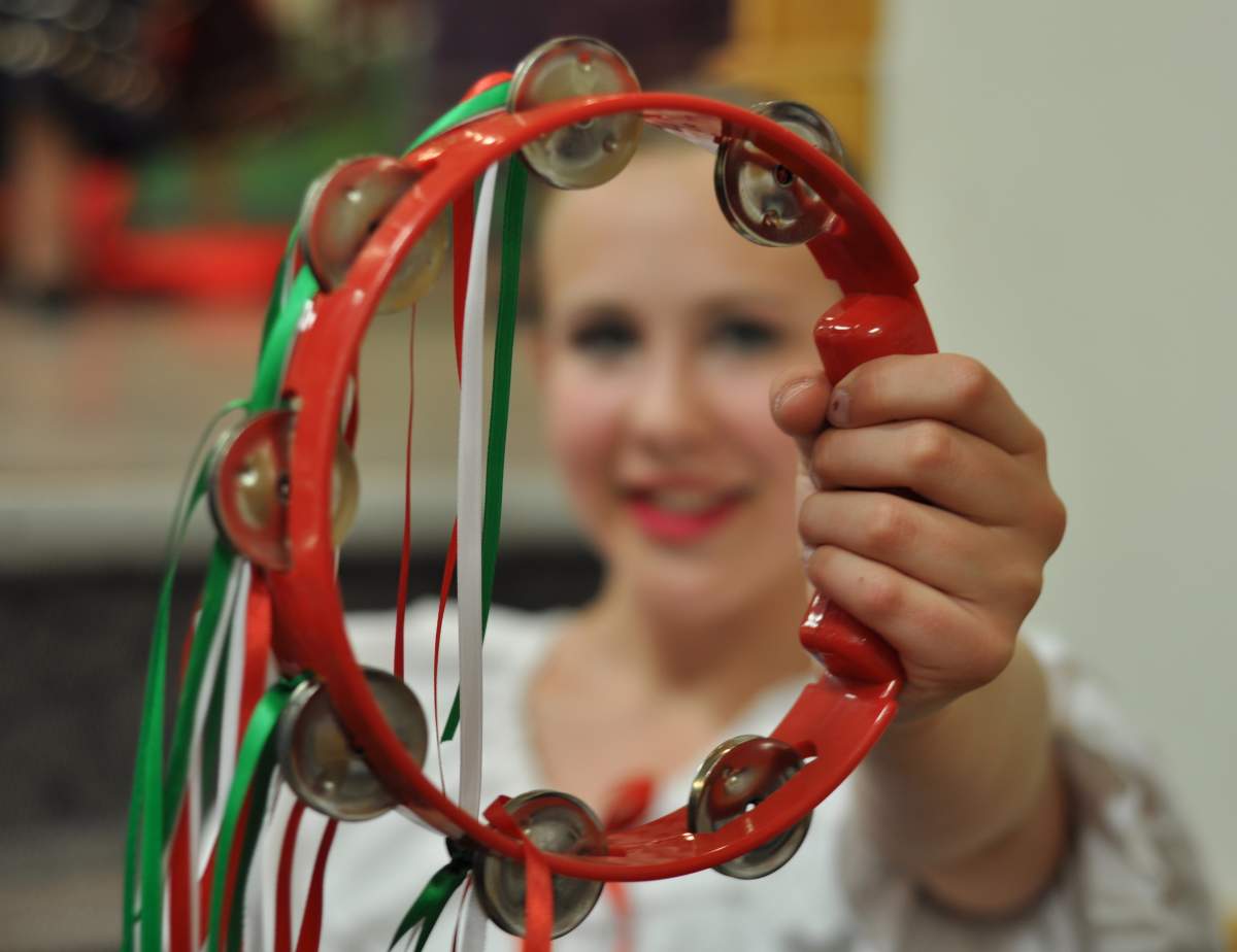 Kathleen Veresh, an Italian dancer, holds up her tambourine. 