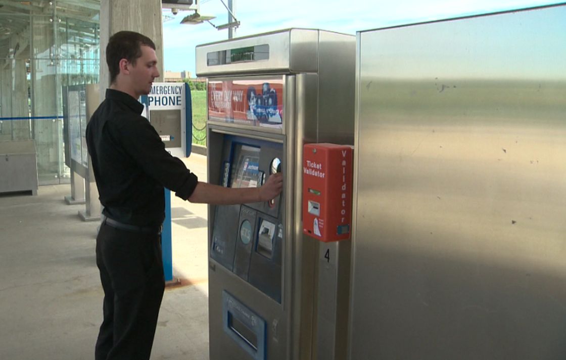 Transit rider Dietrich Neu purchases a ticket at South Campus LRT station. 