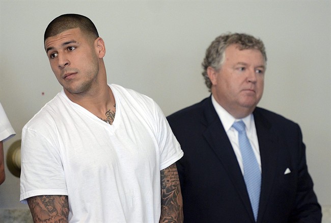 Former New England Patriots tight end Aaron Hernandez, left, stands with his attorney Michael Fee, right, during arraignment in Attleboro District Court Wednesday, June 26, in Attleboro, Mass. Hernandez was charged with murdering Odin Lloyd, a 27-year-old semi-pro football player for the Boston Bandits, whose body was found June 17 in an industrial park in North Attleborough, Mass. 