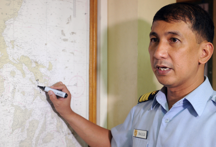Philippine Coast Guard (PCG) spokesperson Commander Arman Balilo points to a Philippine map where the ferry MV Lady of Mount Carmel capsized about two kilometres (1.2 miles) from Burias island, at the PCG headquarters in Manila on June 14, 2013.