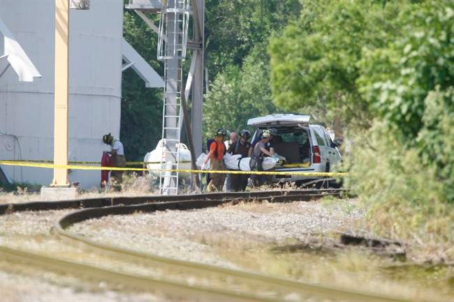 First responders remove a body following an explosion at a grain silo in Union Mills, Ind., on Monday, June 24, 2013. 