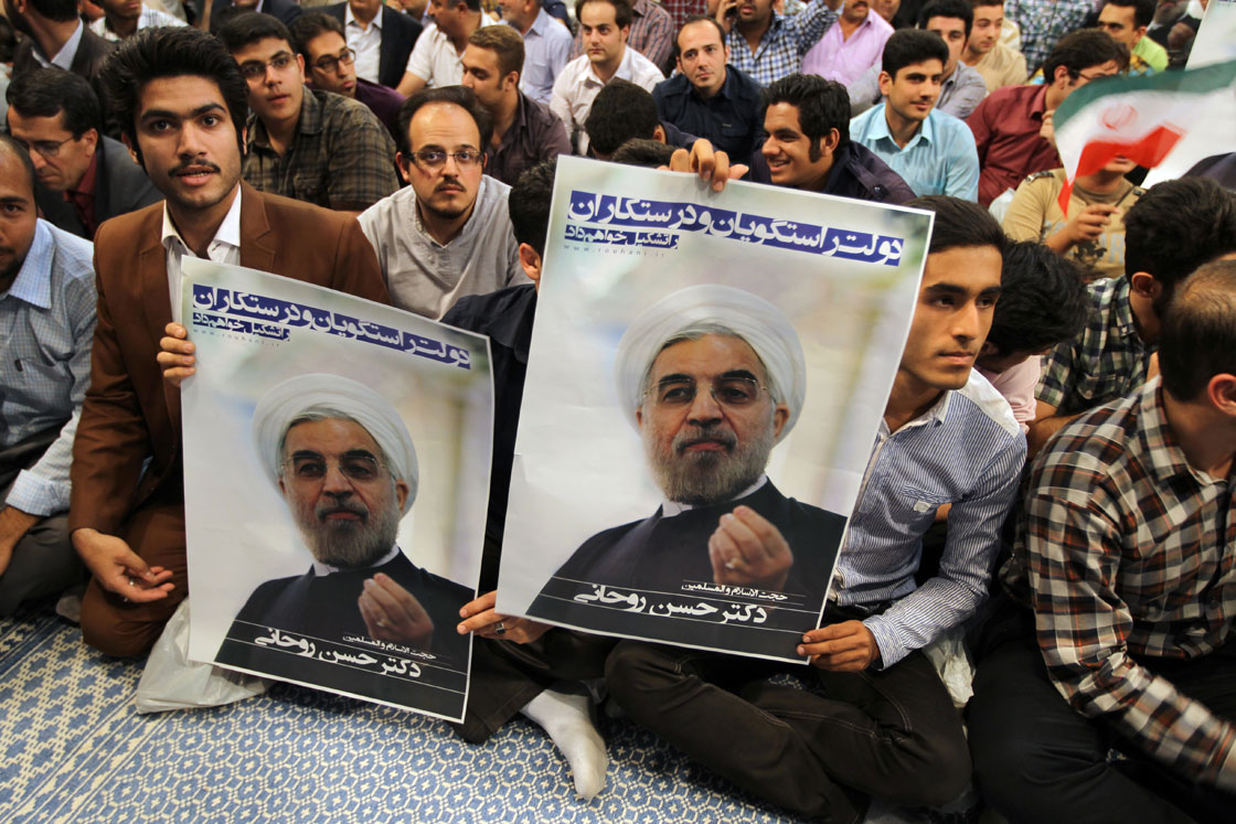 Iranian supporters hold a poster featuring Hassan Rowhani, a moderate Iranian presidential candidate and former top nuclear negotiator, during an election campaign at the Jamaran mosque in Tehran, on June 1, 2013. National elections take place on June 14. 