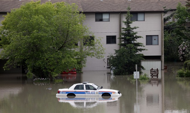 A police car sits in the parking lot of a flooded apartment building in Calgary, Alta. on Friday, June 21, 2013.