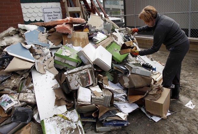 Thaya Gallant helps with the flood clean-up at a law office in Calgary, Alta., Monday, June 24, 2013. Heavy rains caused flooding, closed roads, and forced evacuations across Southern Alberta. 
