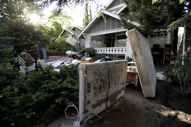 Mud-covered furniture is seen on the front lawn of a home near the Elbow River in Calgary, Alta., Saturday, June 22, 2013. 