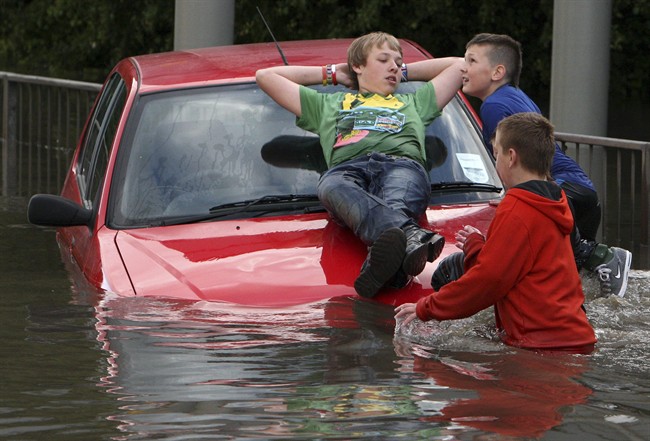 Children play on a stranded car in floodwater in Jarrow, England in 2012. British meteorologists are meeting on Tuesday to discuss the unseasonable weather the country has been experiencing over the past few years.