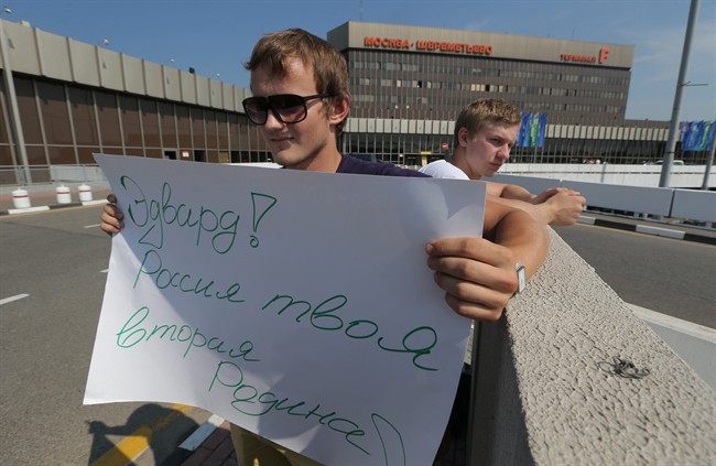 A supporter of National Security Agency leaker Edward Snowden holds a poster outside Sheremetyevo airport in Moscow Friday, June 28, 2013. Russian and foreign journalists continued to monitor the Sheremetyevo international airport, where Snowden is believed to remain at the transit zone. The poster reads : Edward! Russia is your second Motherland! .