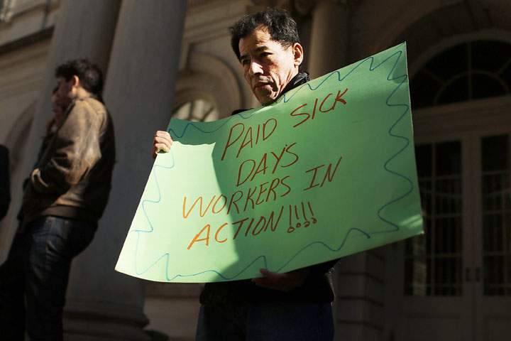 A man holds a sign at a rally in front of City Hall to show support for a paid sick leave bill, a day after New York City Council Speaker Christine Quinn announced that lawmakers and advocates reached a deal on the legislation March 29, 2013 in New York City. 