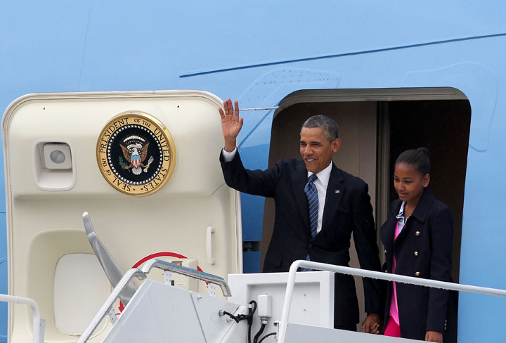 US President Barack Obama waves as he exits Air Force One with his daughter Sasha upon arrival at Belfast International Airport, Northern Ireland, on June 17, 2013, to attend the G8 summit in Enniskillen. 