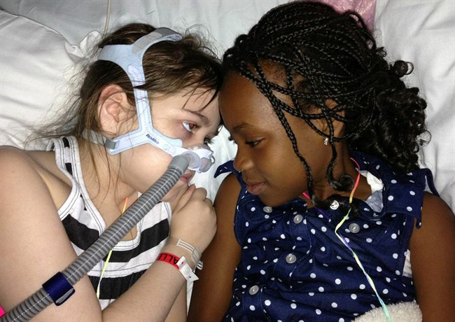 In this May 30, 2013 photo provided by the Murnaghan family, Sarah Murnaghan, left, lies in her hospital bed next to adopted sister Ella on the 100th day of her stay in Children's Hospital of Philadelphia.