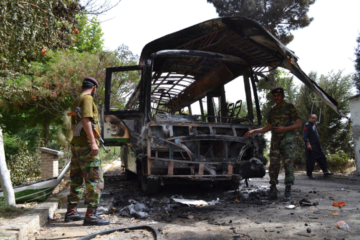 Pakistani security personnel stand near a burnt student bus a day after it was destroyed by a bomb attack, in Quetta on June 16, 2013. 