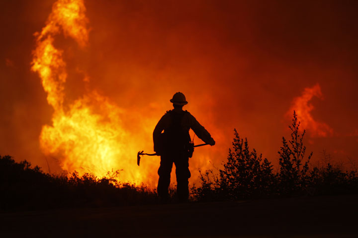Flames rise near a firefighter as the Powerhouse fire makes a fast run toward Lake Hughes on June 1, 2013 south of Lake Hughes, California. 