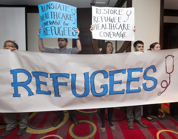 Canadian Doctors for Refugee Care raise a banner.