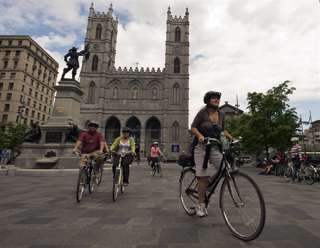 Chantal Doiron, right, leads a bike tour past Notre Dame Basilica Friday, May 17, 2013 in Montreal. 