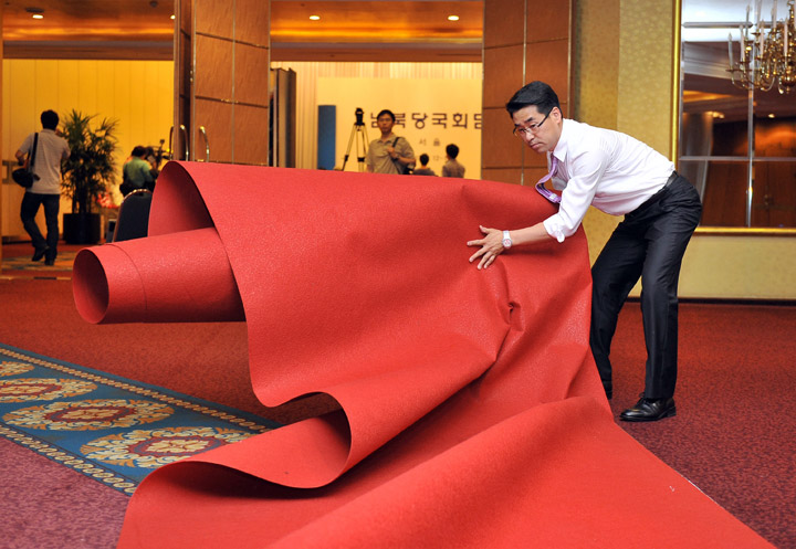 A South Korean worker removes a carpet at the venue for the inter-Korean talks after their cancellation at a hotel in Seoul on June 12, 2013. The first high-level talks between North and South Korea for six years were called off at the last minute on June 11, because of a dispute over the status of their respective chief delegates.