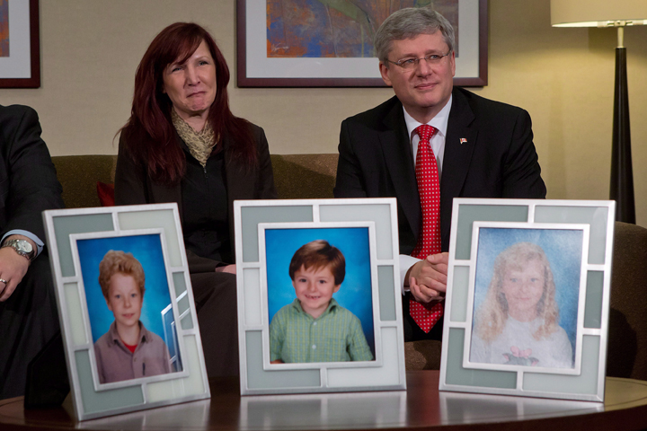Darcie Clark's cousin Stacy Galt, left, sits with Prime Minister Stephen Harper during a photo opportunity before he announced the Conservative government is providing courts with new powers to lock up people found not criminally responsible for their crimes due to mental problems, in Burnaby, B.C., on Friday, February 8, 2013.