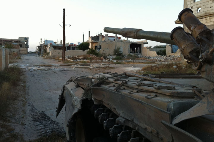 Syrian army troops patrol in a tank the ruined streets of Dabaa, north of Qusayr, in Syria's central Homs province on June 6, 2013, after government forces seized total control of the former rebel-stronghold. 