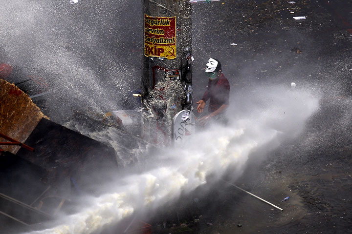 A protester is sprayed by a water cannon during clashes in Taksim Square in Istanbul, Tuesday, June 11, 2013. 
