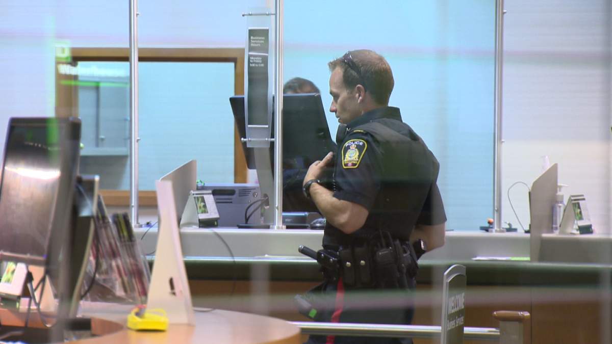 A Winnipeg police officer investigates a robbery at the TD Bank at 201 Portage Ave. on Tuesday.