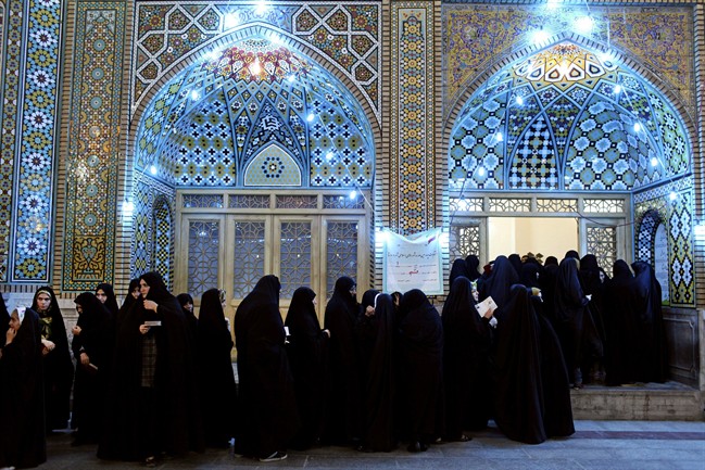 Iranian women, queue, in a polling station to vote for the presidential and municipal councils elections, in the city of Qom, 125 kilometers south of the capital Tehran, Iran, Friday, June 14, 2013. I.