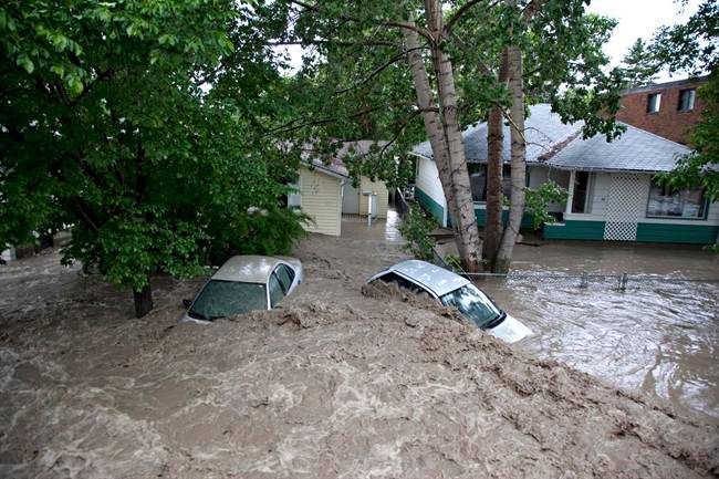 Submerged cars sits in the flood waters in High River, Alta. on June 20, 2013 after the Highwood River overflowed its banks. 