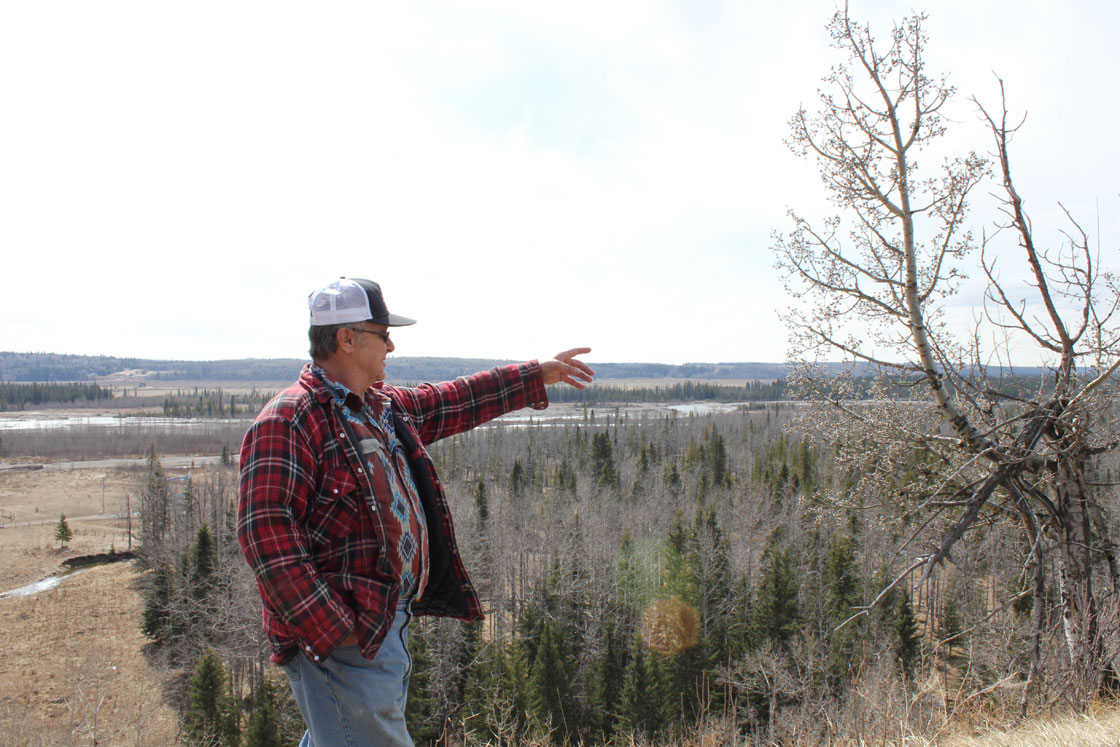 Wayne Johnston points to the riverbank.