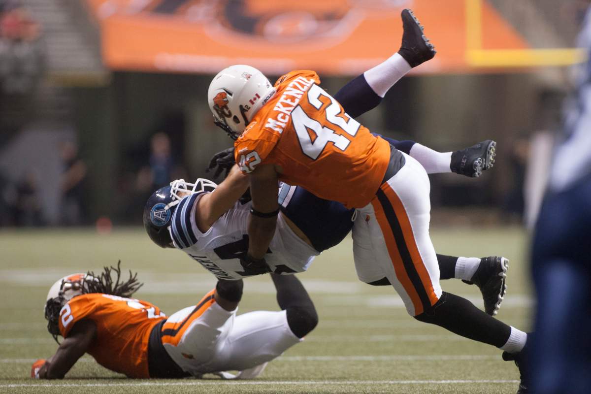 B.C. Lions' Anton McKenzie knocks over Toronto Argonauts' Chad Kackert during second half CFL football in Vancouver, B.C. on Thursday, July 4, 2013. 