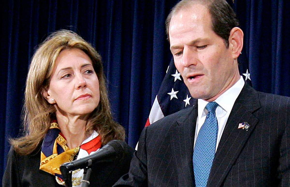In this March 12, 2008, file photo, New York Gov. Eliot Spitzer announces his resignation amid a prostitution scandal as his wife Silda stands by at the governors office in New York. Silda Wall Spitzer, who stood by her husband during the announcement, is nowhere to be found on the campaign trail as the former governor attempts a political comeback as New York City comptroller.