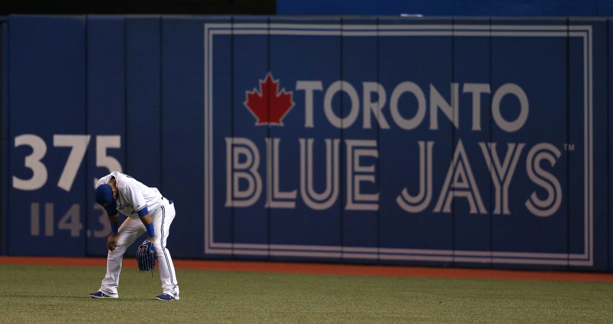 Jose Bautista hangs his head in right field after a Yasiel Puig tenth inning homer as the  Toronto Blue Jays lose to the Los Angeles Dodgers 8-3 in 10 innings  at the Rogers Centre in Toronto,   July 24, 2013.