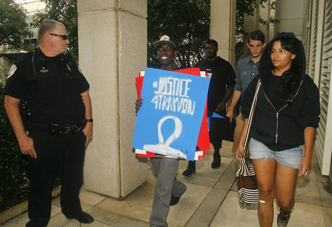 A Capitol police officer watches as protestors walk by him Tuesday July 16, 2013 at the Capitol in Tallahassee, Fla.