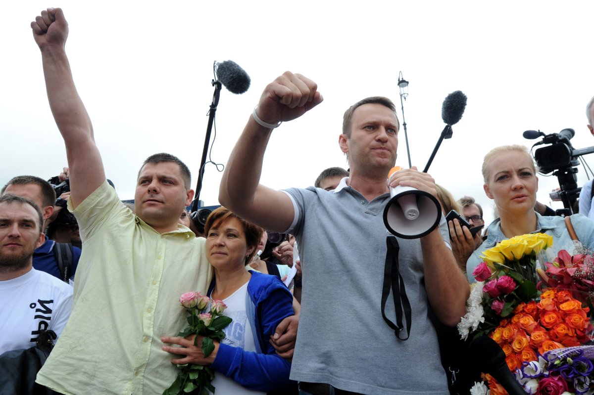 Russia's top opposition leader Alexei Navalny (C-R), flanked by his wife Yulia (R), addresses supporters and journalists upon his arrival in a Moscow's railway station on July 20, 2013. Navalny told hundreds of cheering supporters on Saturday that he would push ahead with his bid to become Moscow mayor after his surprise release from jail pending an appeal of an embezzlement conviction.