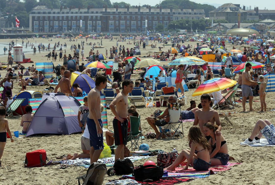 People head to the beach in Weymouth, England. The country has endured temperatures in the 30s for the past week.