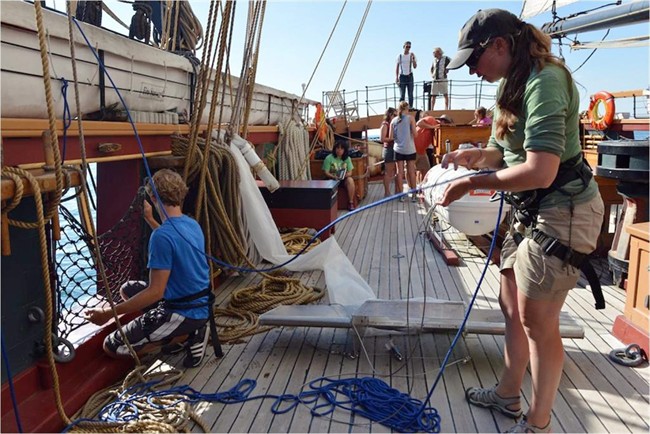 In this 2012 photo provided by 5gyres.org, Sherri Mason, right, a chemist with State University of New York at Fredonia and one of the project leaders, works aboard a research vessel on Lake Erie with a device that skims the water surface collecting samples in finely meshed netting. 
