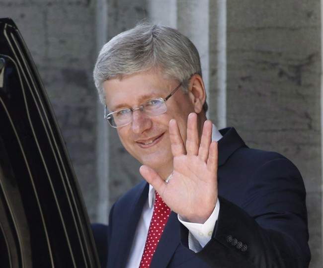 Prime Minister Stephen Harper waves as he leaves the swearing in of the federal cabinet at Rideau Hall in Ottawa on July 15, 2013. 