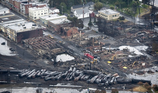 Workers comb through the debris after a train derailed causing explosions of railway cars carrying crude oil Tuesday, July 9, 2013 in Lac-Megantic, Quebec. THE CANADIAN PRESS/Paul Chiasson.