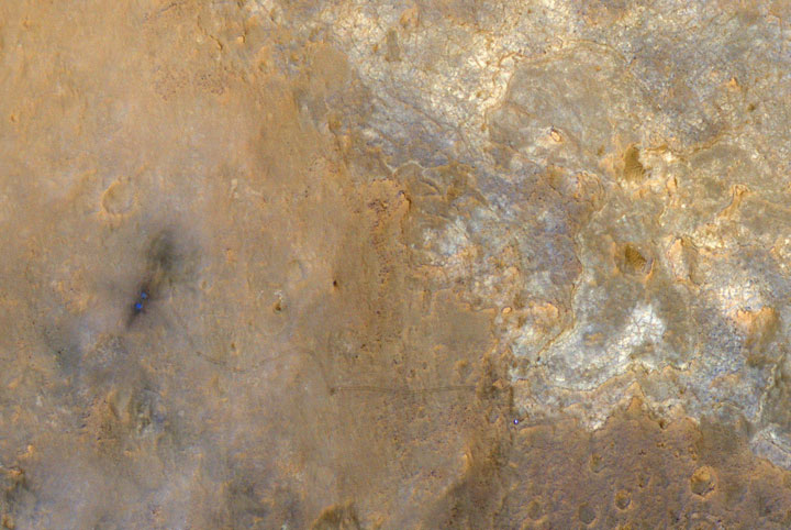 In this image, Curiosity appears as a blue dot near the lower right corner of this enhanced-colour image by the High Resolution Imaging Science Experiment (HiRISE) on the Mars Reconnaissance Orbiter. The image was taken on June 27, 2013.