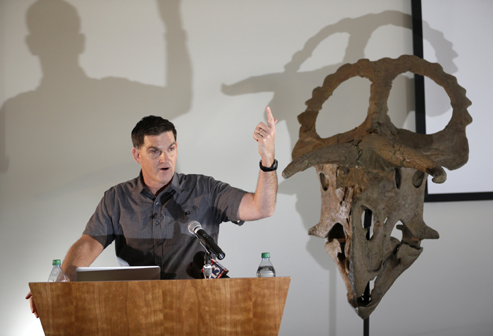 Dinosaur paleontologist Scott Sampson,makes remarks as he stands next to a reconstruction of a "Nasutoceratops titusi" during a news conference at the Natural History Museum of Utah Wednesday, July 17, 2013, in Salt lake City. 