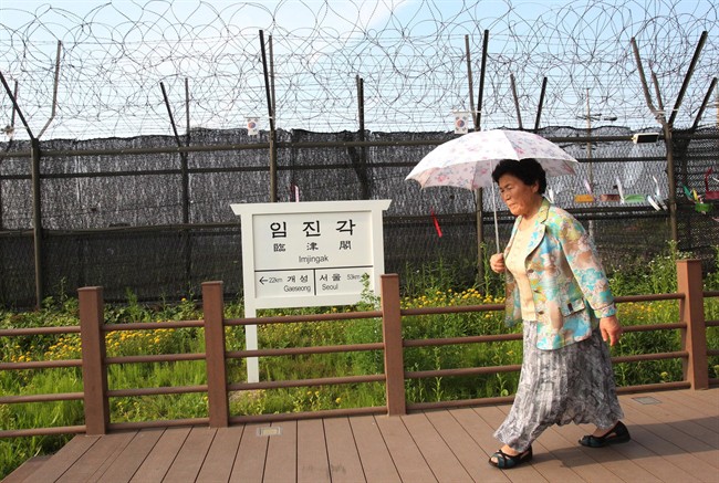 A visitor walks by a sign showing the distance to North Korea's Kaesong city and South Korea's capital Seoul at the Imjingak Pavilion near the border village of Panmunjom that has separated the two Koreas since the Korean War, in Paju, South Korea, June 10, 2013. 