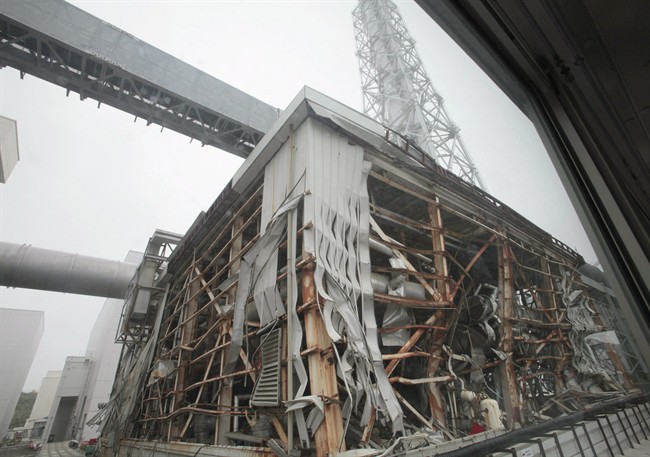 In this June 12, 2013 photo, the crippled Fukushima Dai-ichi nuclear power plant is seen through a bus window in Okuma, in Fukushima prefecture. 