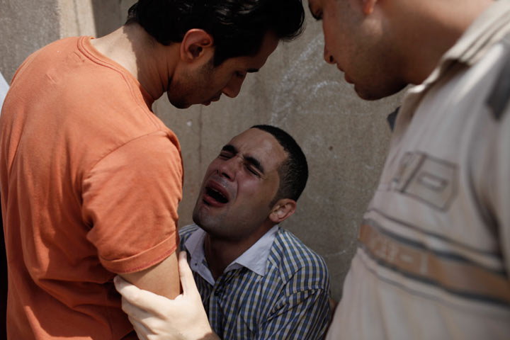 A man reacts after seeing the body of a family member, allegedly killed during a shooting at the site of a pro-Morsi sit-in in front of the headquarters of the Egyptian Republican Guard, at the Liltaqmeen al-Sahy Hospital in Cairo's Nasr City district on July 8, 2013 in Cairo, Egypt. 