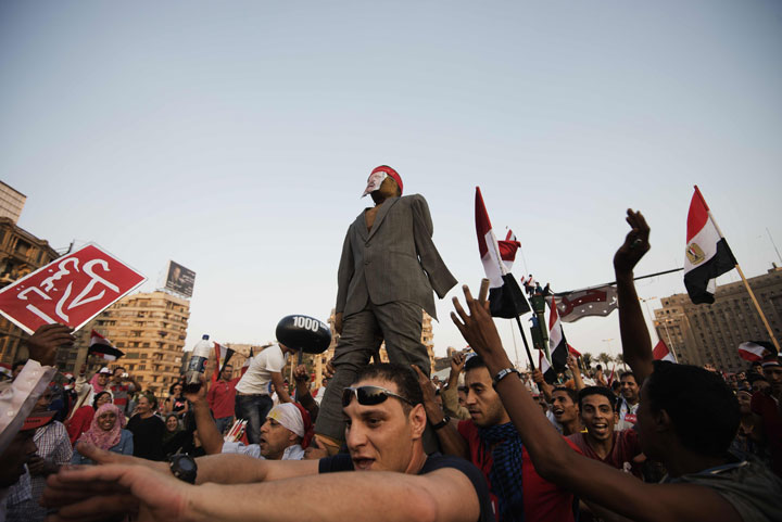 Egyptian opposition protestors beat a dummy of President Mohamed Morsi in Cairo's landmark Tahrir Square on July 3, 2013.
