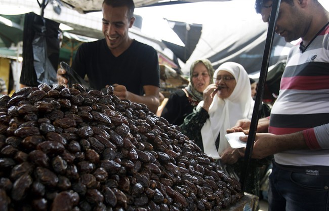 A Palestinian vendor sells dates for Ramadan at a market in the West Bank city of Jenin, Monday, July 8, 2013. 