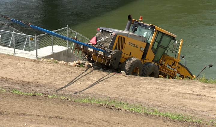 A submerged construction grader was towed out of the South Saskatchewan River on Monday.