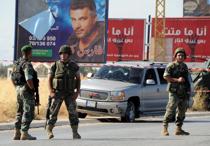 Lebanese soldiers stand guard at the site of a car bomb attack that hit a Hezbollah convoy travelling towards the Lebanese border crossing with Syria, on the Majdal Anjar-Masnaa road on July 16, 2013. 
