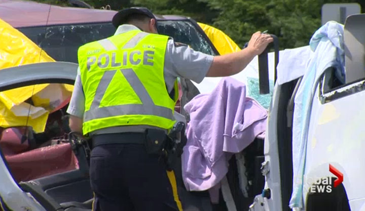 Police work the scene of a July 20, 2013 head-on collision that claimed multiple lives on Highway 103 in Nova Scotia.