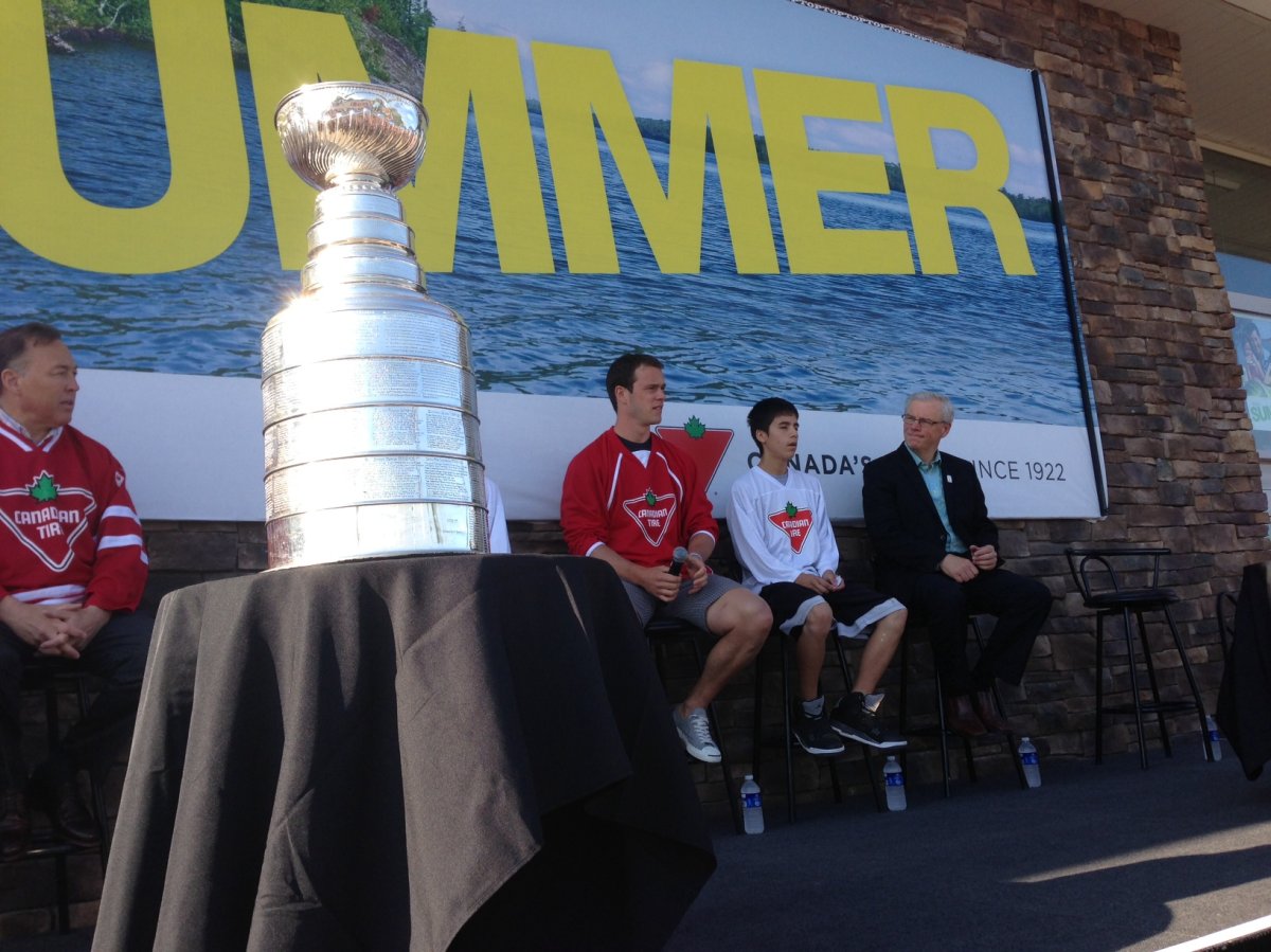 Jonathan Toews (second from the left) and Manitoba Premier Greg Selinger (right)  appear with the Stanley Cup at the Southdale Canadian Tire in Winnipeg on Friday.