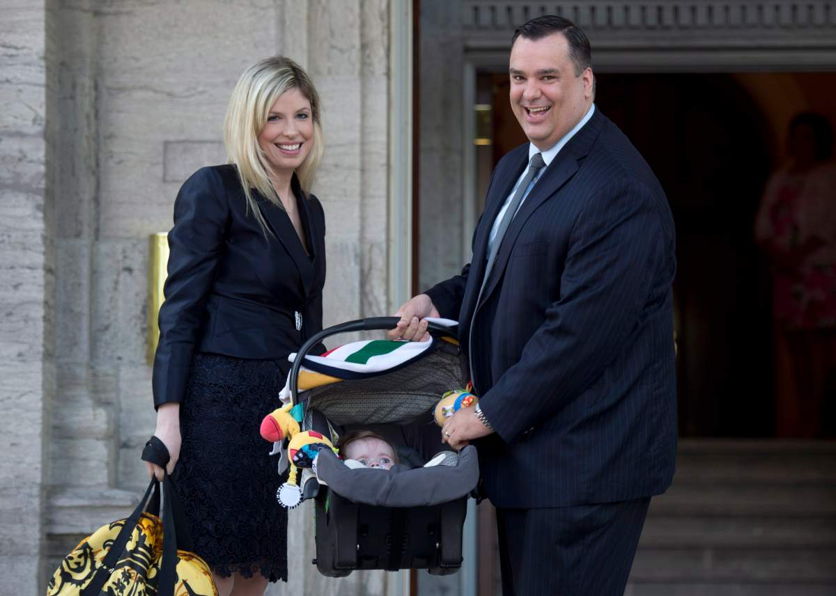 James Moore and his wife Courtney Payne stop with their child, Spencer, as they arrive for a cabinet shuffle at Rideau Hall in Ottawa on July 15, 2013. Moore was sworn in as minister of industry. THE CANADIAN PRESS/Adrian Wyld