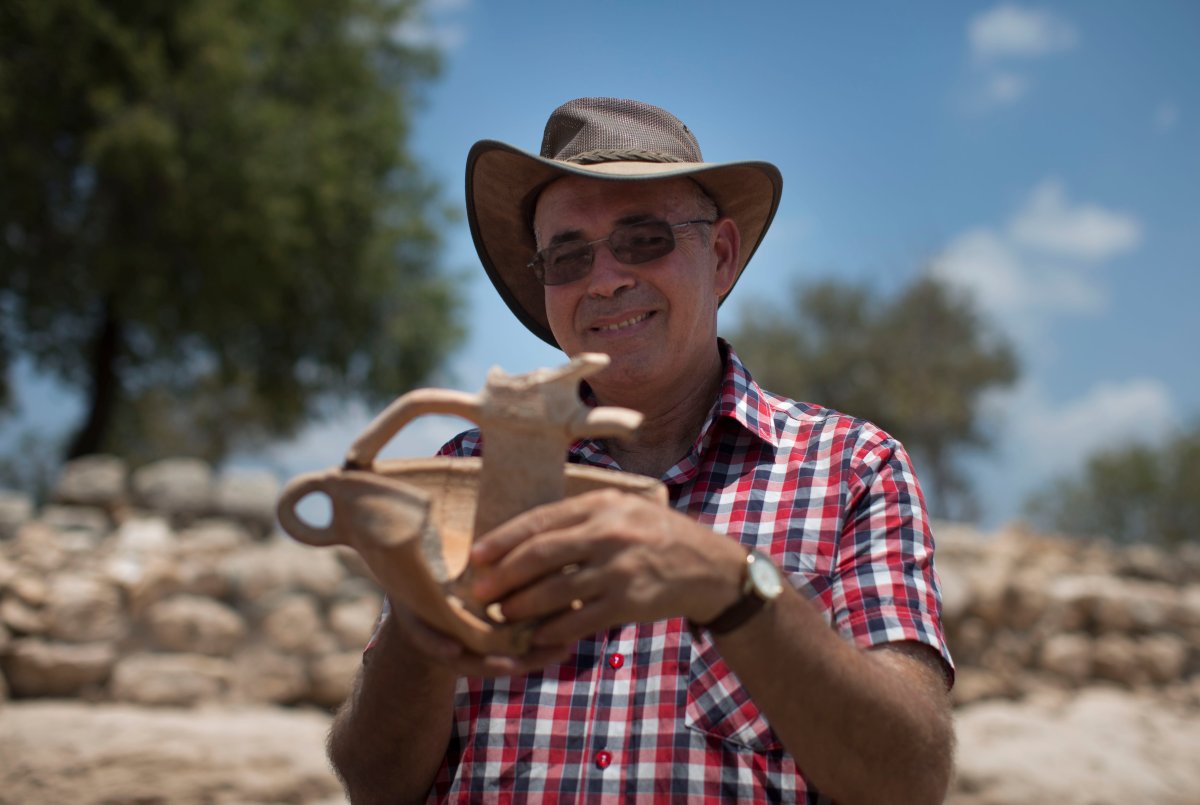 ISRAEL - JULY 18:   Professor Yossi Garfinkel holds an article from his archaeological excavation next to the remains of what is thought to be King David's palace, one of two royal public buildings that were found during archaeological excavation in what is believed to be the Kingdom of Judah of the tenth century BCE, on July 18, 2013 in Khirbet Qeiyafa, Israel. The findings were uncovered this past year by researchers at the Hebrew University and the Israel Antiquities Authority. One of the buildings is identified by the researchers, Professor Yossi Garfinkel of the Hebrew University and Saar Ganor of the Israel Antiquities Authority, as David's palace, and the other structure as a royal storeroom. 