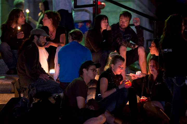 People gather in front of the St-Agnes church during a vigil for the victims of the train crash Lac-Megantic, Que., Friday, July 12, 2013.